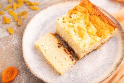 ?ottage cheese ?asserole, Curd cake, with dried apricots and raisins on brown concrete background