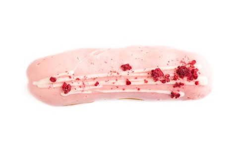 Glazed pink Eclair on brown concrete isolated on white, top view, flat lay, close up