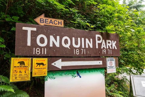 Wooden sign indicating tonquin park with directions to the beach and warnings about bears and