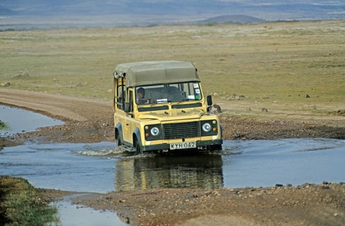 Safari vehicle driving through pools of water, Amboseli National Park, Kenya, Africa, June 2000,