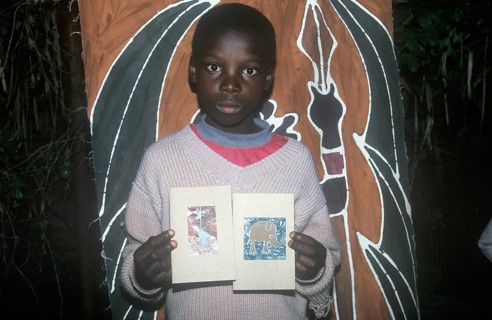 Child with homemade artwork in a self-help project in Chitungwiza near Harare, Zimbabwe, Africa,