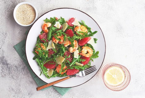 Fresh shrimp salad with arugula, grapefruit, and parmesan served in a bowl
