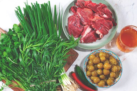 Ingredients for cooking chakapuli, canned tkemali, meat, herbs Georgian cuisine, top view