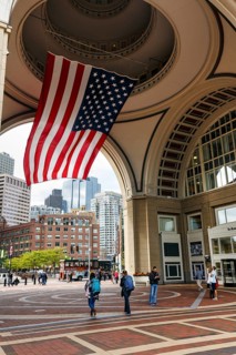 American flag fluttering, distinctive archway, Boston Harbor Hotel, Rowes Wharf, passers-by,