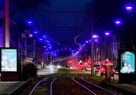 The blue light strip shines into the dark sky above Kurt-Schumacher-Straße in Schalke,