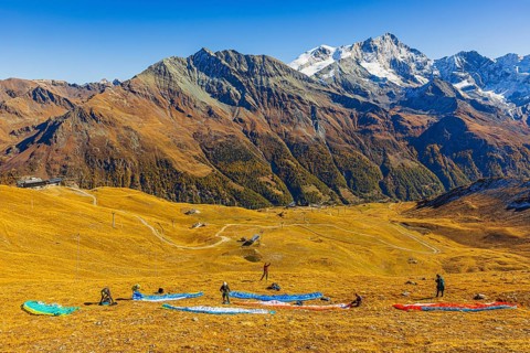 Paragliders prepare their start, summit of the Corne de Sorebois, with the backdrop of the Valais