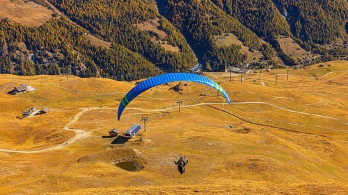 A paraglider takes off from the summit of Corne de Sorebois, Val d'Anniviers, Valais Alps, Canton