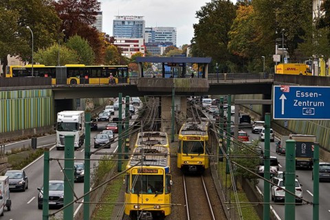 Lots of traffic on the A 40 motorway on four lanes and two subways on two lanes and a bus on the