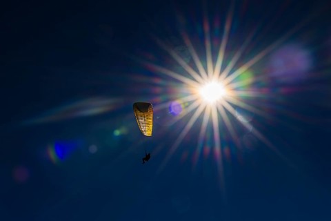 Paragliders against blue sky and bright sun, Val d'Anniviers, Valais Alps, Canton of Valais,