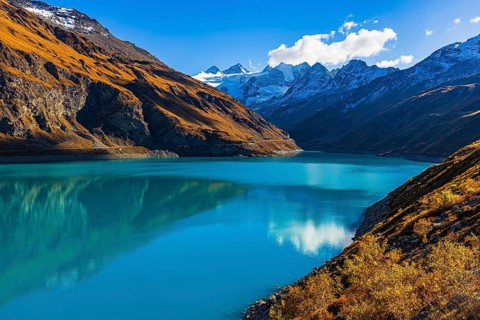 The Lac de Moiry reservoir, with the snow-capped peaks of the Grand Cornier, Tete Blanche and
