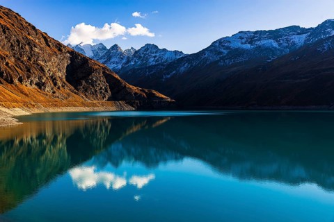 The turquoise Lac de Moiry reservoir, behind the peaks of the Grand Cornier, Tete Blanche and