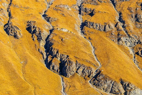 Steep and rocky mountainside in autumn colors, near the Lac de Moiry reservoir, Val d'Anniviers,