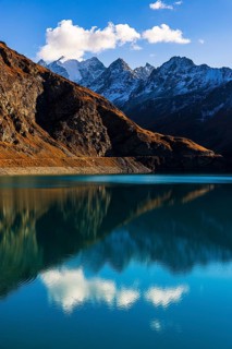 The turquoise Lac de Moiry reservoir, behind the peaks of the Grand Cornier, Tete Blanche and