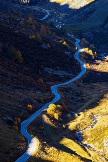The mountain road from Grimentz to the Lac de Moiry reservoir with autumn colors, Val d'Anniviers,