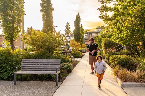 Father and son are enjoying a leisurely walk through a tree lined residential street in vancouver,