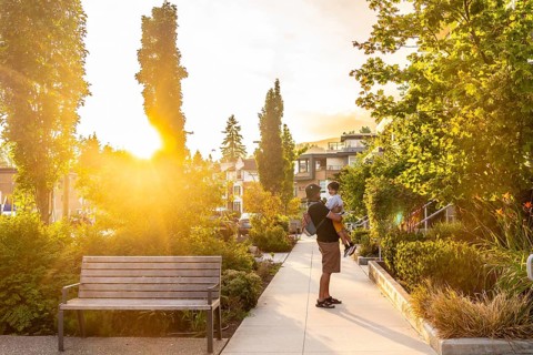 Father holding his son in a residential neighborhood of vancouver, british columbia, during a