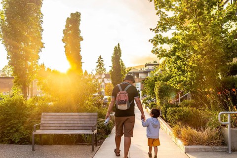 Father and son walking hand in hand at sunset in vancouver, cherishing quality moments together in