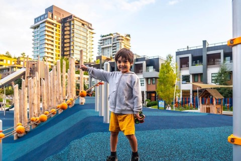 Cheerful child enjoys playing on a colorful and safe playground in vancouver, surrounded by modern