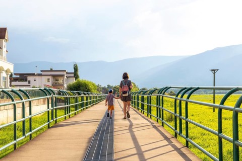 Mother and son enjoying a leisurely stroll on a pedestrian bridge in salmon arm, british columbia,