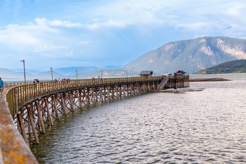 Tourists are enjoying a sunny day walking on the longest wooden wharf in north america, located in