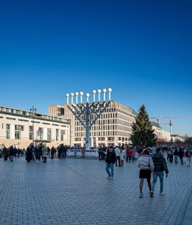 Large Hanukkah chandelier at the Brandenburg Gate in daylight, sign of lively Jewish life, symbolic