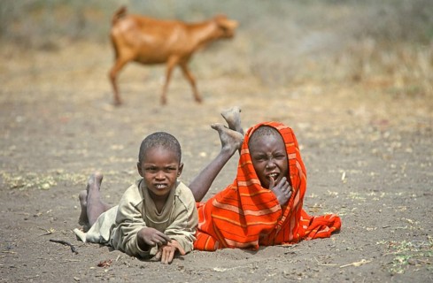 Maasai children lying on the ground in front of their village, goat, Ngorongoro Crater, Tanzania,