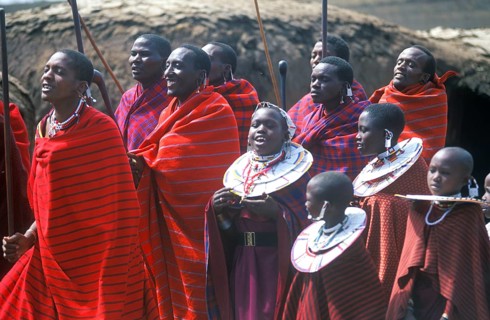 Maasai men and girls in their village in the Ngorongoro Crater dancing for tourists, Tanzania,