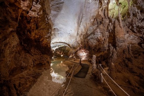 Stalactites and stalagmites, reflection in a small underground lake, rock formations in a