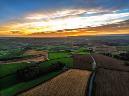 Sunset of Devon Farms and Fields over Berry Pomeroy from a drone, Totnes, England, United Kingdom