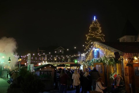 A festive Christmas market at night with glowing lights and a decorated Christmas tree, Winterberg,