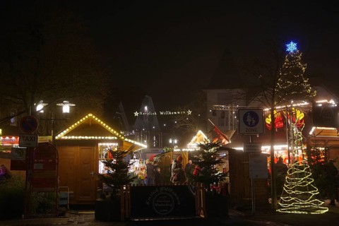 An atmospheric Christmas market in the dark with festively decorated huts and trees, Winterberg,