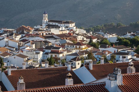View over village Yunquera, church and typical white houses, mountain range Sierra de las Nieves,