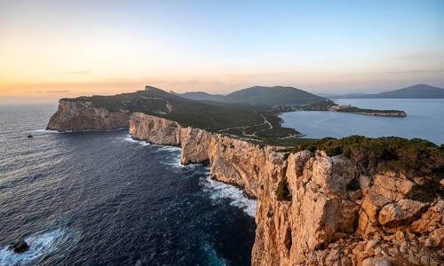 Coastal landscape at sunset, steep cliffs by the sea, cliffs in the evening light, Capo Caccia,