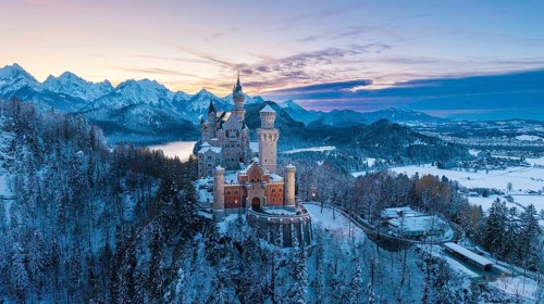 Neuschwanstein Castle at sunset with snowy mountains, Schwangau near Füssen, Ostallgäu, Allgäu,