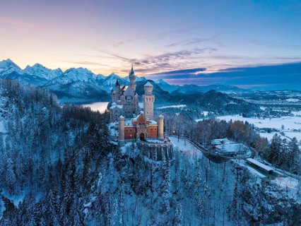 Winter evening with Neuschwanstein Castle and a peaceful landscape of mountains and snow in soft