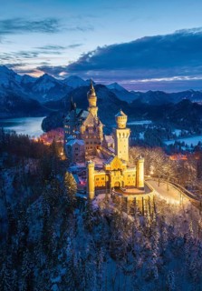 Illuminated Neuschwanstein Castle in a snowy mountain landscape at dusk, night view, Schwangau near