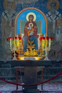 Icon of the Mother of God and Child Jesus surrounded by candles and flowers on an altar, Akhtala