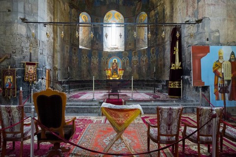 Church room with altar and religious icons decorated with carpets and candles, Akhtala monastery,