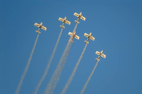 Stunt aerobatic planes performing stunts in blue sky with smoke trail. Concept of teamwork,