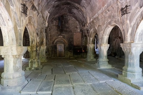 Vaulted room with stone structures and subdued lighting creates a cool atmosphere steeped in