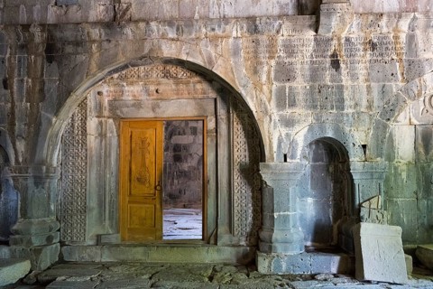 Ancient entrance with artfully carved wooden door and stone arches, Sanahin monastery, Sanahin