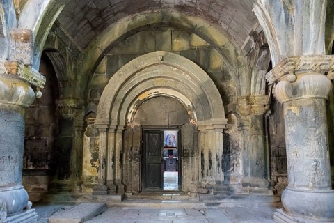 Ancient building entrance with stone arches and a central wooden door, Sanahin monastery, Sanahin