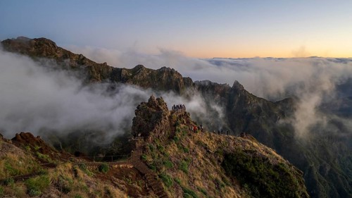 Sunrise at Pico do Arieiro, clouds of fog pass over mountain peaks, hiking trail PR1, Madeira,