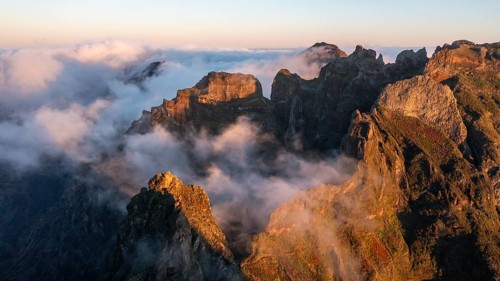 Aerial view, sunrise at Pico do Arieiro, clouds of fog sweeping over mountain peaks, Madeira,