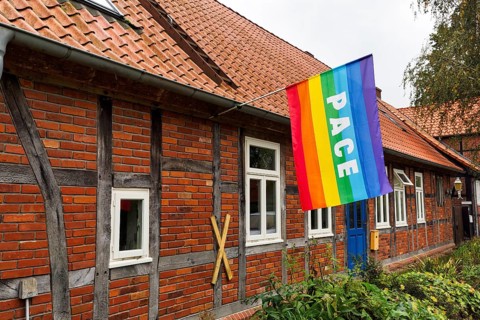 International peace flag on a private house, pace flag, rainbow flag with the inscription peace,