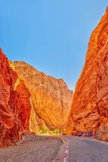 A narrow gorge with glowing red rocks under a clear blue sky, Morocco, Todra Gorge