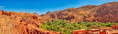 Red rock landscape with green trees under clear sky, Morocco, Dade Valley, Monkey Finger, panorama