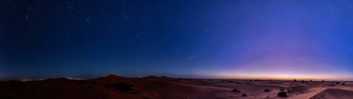 Starry sky over a desert-like landscape at dusk, Morocco, Sahara, in front of sunrise, panorama