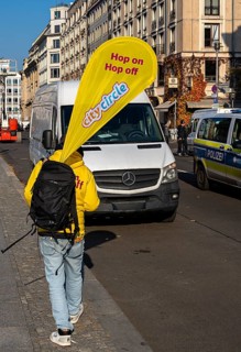 Cityscape, A man carrying the advertising banner of the Hop on Hop off buses from City Circle,