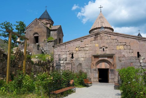 Historic monastery with towers and stone walls, surrounded by garden, Goshavank monastery, Tavush